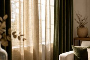 Rideaux en lin et velours filtrant la lumière dans un intérieur chaleureux