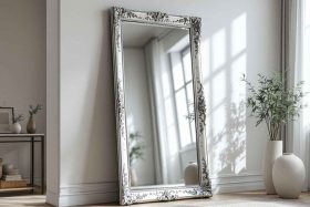 Un grand miroir élégant posé contre un mur nu dans un salon, créant une illusion d'espace plus grand et ajoutant de la lumière à la pièce